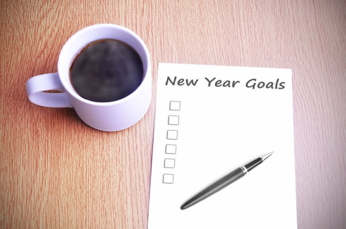 Checklist of new years goals next to cup of coffee