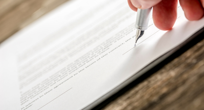 An image of a person writing a report with a pen.