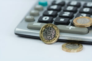 Coins placed on top of a calculator on a desk