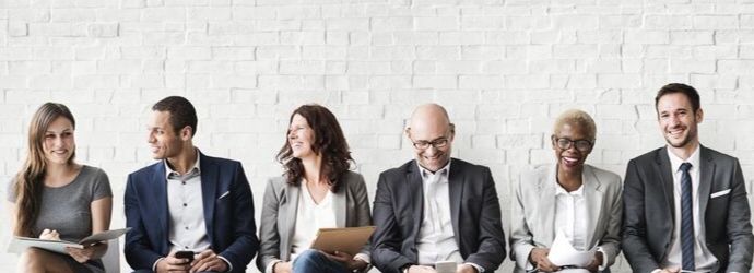 Group of people dressed in business attire chatting 