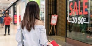 Woman holding shopping bags at shopping centre during Black Friday sales