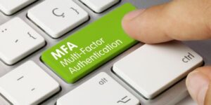 Finger pointing to button on computer keyboard that reads 'Multi-Factor Authentication'