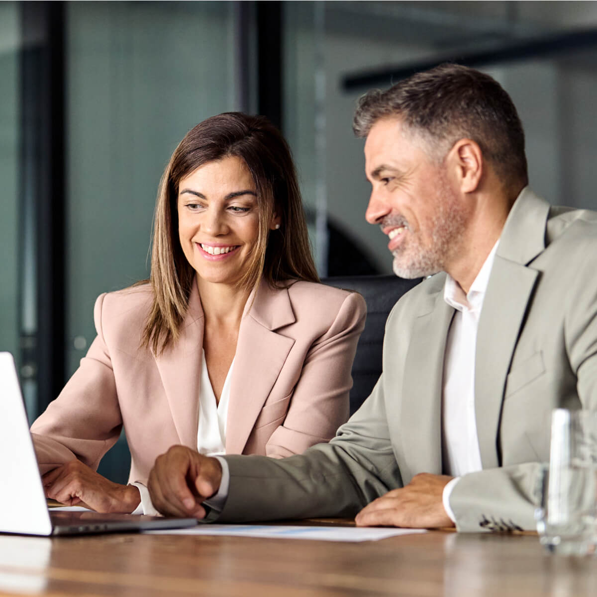 Business Meeting Collaboration – Professionals Discussing Expenses on Laptop