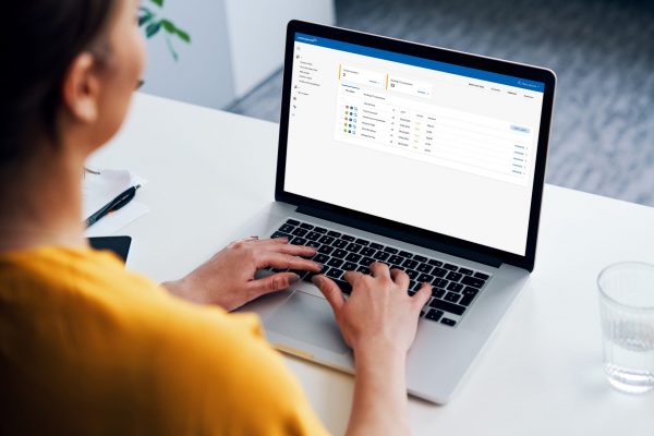 Woman working on laptop with Webexpenses system showing on screen