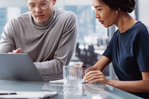 Two Professionals Collaborating Over Laptop